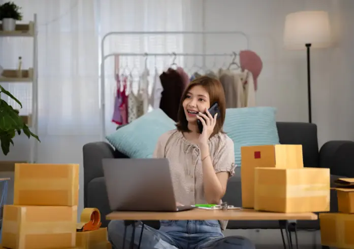 smiling-happy-young-asian-woman-entrepreneur-receiving-phone-call-new-sales-order-boxes-product-with-laptop-computer Smiling happy young asian woman entrepreneur receiving phone call new sales order boxes product with laptop computer